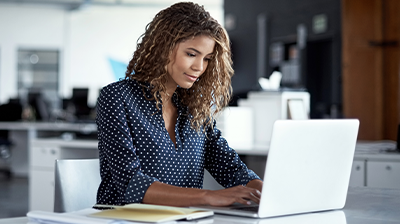 Insurtech: The Industry Buzzword That Never Stops Trending A woman typing on her laptop while sitting at a desk in an office