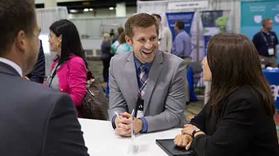 Business people at a conference chatting at a stand